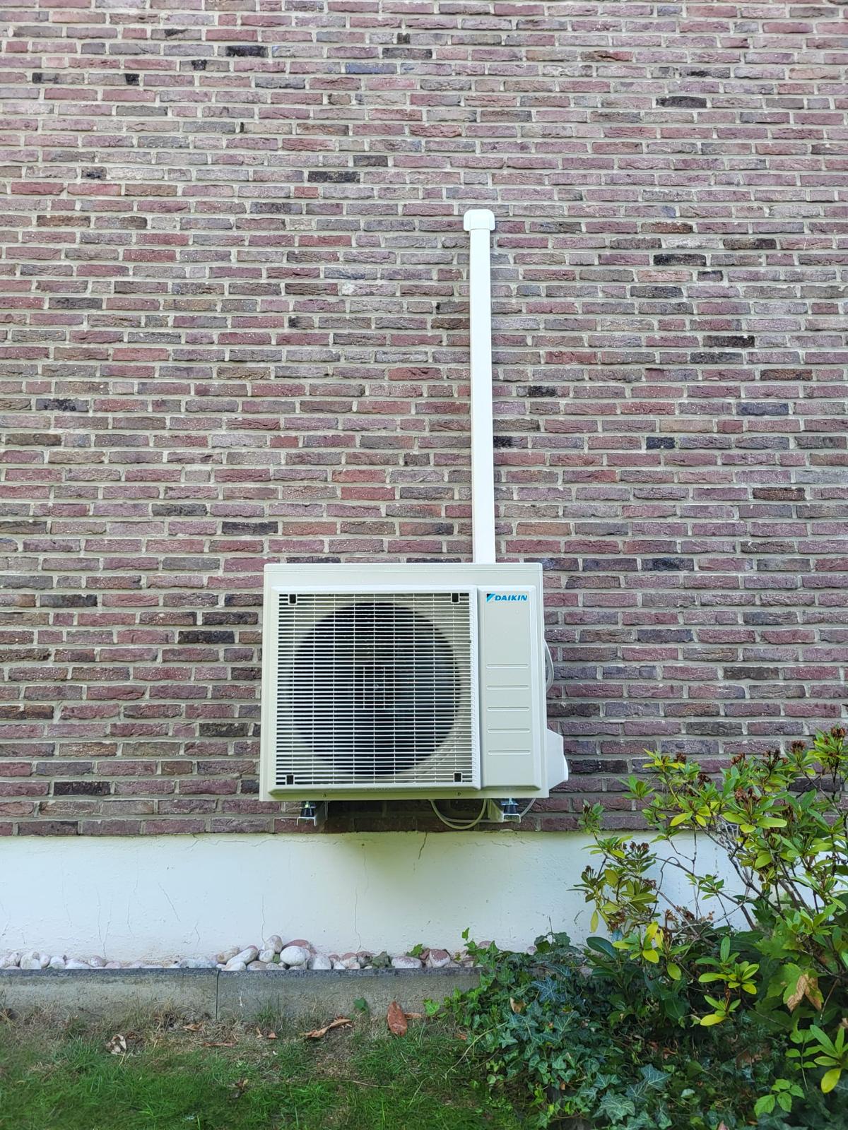 Daikin buitenunit gemonteerd aan een bakstenen gevel