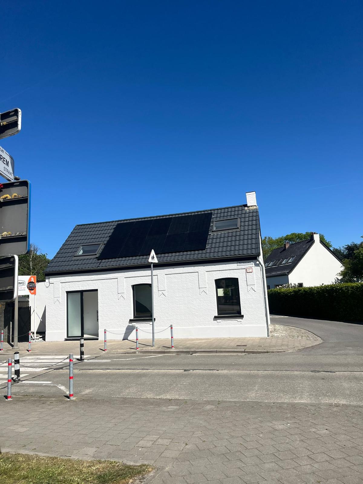 Zonnepanelen op pannendak van wit hoekhuis